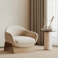 Beige Accent Chair with Wooden Base in Cozy Modern Interior Side Table Vases and Books