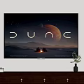 Wall Mounted TV Displaying Dune Desert Landscape With Planet On Wooden Cabinet With Decorative Items