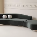 Unique Shaped Dark Green Curved Sofa With White Balls On Light Floor Against Decorative Wall