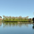 Serene Lakeside Scenery With Wooden Boardwalk Gravel Ground And Lush Vegetation