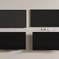 Four Black TVs Mounted on Light Colored Wall with Small Controllers Below Top Right TV 3d model