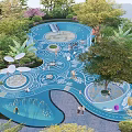 Vibrant Kids Playground With Blue Curved Surface Greenery And Play Structures 3d model