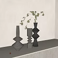 Minimalist Decorative Geometric Vases In Gray Black With Leafy Sprigs On White Countertop