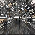 Tunnel of Screens Displaying Black and White Photos with Years and Person Walking