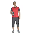 Man in red vest and gray capri pants holding a water bottle against gray background