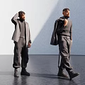 Two Men In Stylish Grey Outfits Adjusting Hair And Holding Coat Light Wall Dark Floor