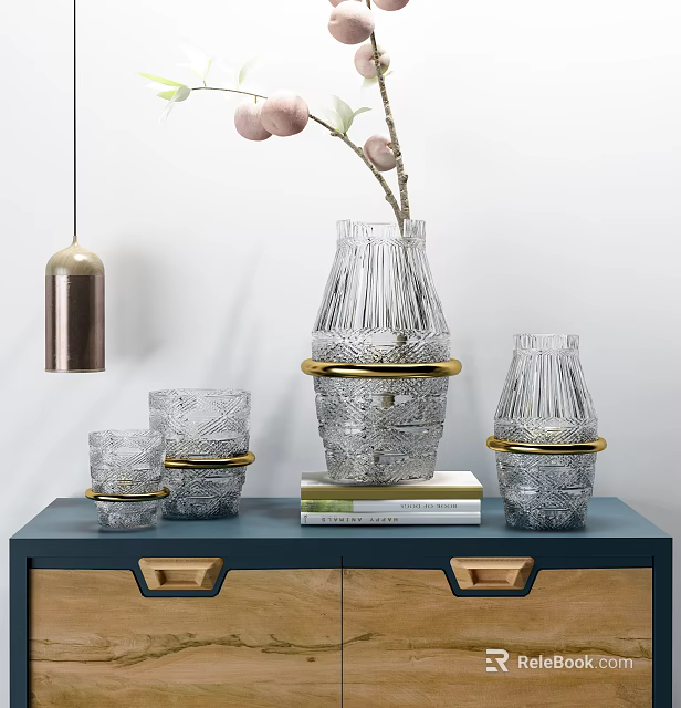 Transparent Glass Decorative Ornament Set With Gold Accents On Blue Cabinet And Books 3d model 