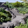 Natural Outdoor Rocky Stairs Surrounded By Lush Green Plants And Flowers