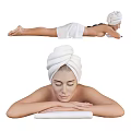 A Woman with Towel Wrapped Head Lying on Stomach During Relaxing Massage with Hot Stones