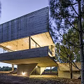 Modern Vacation Rental Building With Concrete Cantilevered Design Surrounded By Trees And Large Windows