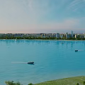 Scenic View of Calm Water With Helicopter Small Boats Distant City Buildings And Clear Sky