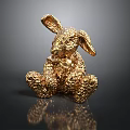 Decorative Golden Rabbit Figurine Sitting With Textured Metallic Surface On Black Reflective Base