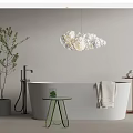 Modern White Bathtub with Cloud Shaped Pendant Light Green Side Table Hanging Towel and Plant