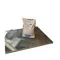Construction Material Bag With Blue Label And Spilled Powder On Concrete Platform