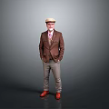 Man In Brown Blazer Light Colored Pants Red Shoes And Hat Standing On Gray Background