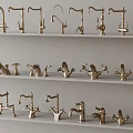 Assorted Brass Faucet Styles Displayed on Multiple White Shelves in Showroom