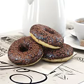 Cup of Coffee with Chocolate Donuts White Teapot and Sugar Cubes on Patterned Mat