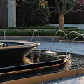 Elegant Illuminated Water Fountain With Modern Building Backdrop And Landscaped Surroundings