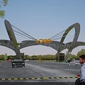 Modern Entrance Gate Design With Curved Glass Structure Logo Cars And Pedestrians