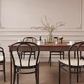 Modern Wooden Dining Table Set with Black Woven Back Chairs Vase White Flowers Coffee Cups