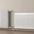 Sleek White Heating Radiators Against Light Wall With Wooden Floor In Home Interior