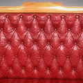 Classic Red Leather Single Sofa With Carved Wooden Arms And Tufted Seat