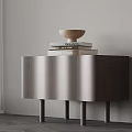 Modern Nightstand with Curved Front Design and Stack of Books with Decorative Bowl