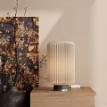 Pleated Table Lamp on Wooden Tabletop with Beige Wall and Golden Flower Branches