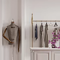 Elegant Clothing Store With White Walls Golden Racks Mannequin Brown Sofa And Purple Flowers