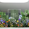 Colorful Floral Installation Featuring Various Flowers and Green Plants in Modern Interior with Green Signage