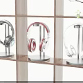 Modern Headphones In Black Red White With Stands On Wooden Shelf