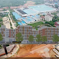 Aerial View of Modern School Campus Buildings With Green Rooftops Surrounding Roads and Sports Field