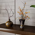 Brown And Black Metal Base Vases With Dry Branches And Orange Flowers On Wooden Shelf