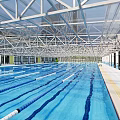 Indoor Swimming Pool with Glass Roof Swimming Lanes Clear Water Steel Structure and Bright Interior