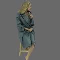 Blonde woman wearing gray robe sitting on wooden chair adjusting necklace against gray background