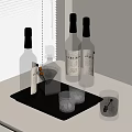 Amber Liquor Bottles and Assorted Glasses on Black Tray by White Blinds Table