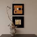 Black Framed Oil Paintings With Orange White Hues Hanging On Beige Wall Near Silver Vase