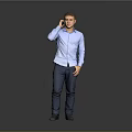 A Man Talking on the Phone in Blue Shirt and Dark Pants Against Gray Background
