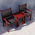 Two Mahogany Armchairs With Black Cushions And Small Wooden Table In Gray Room