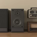 Black Stereo Speakers and Vintage Radios on Wooden Floor Against Beige Wall with Classic Design