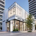 Modern Commercial Complex with Glass Facade Main Entrance Amidst High Rise Buildings and Open Plaza