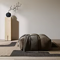 Minimalist Gray Ottoman With Draped Blanket On Geometric Rug Near Wooden Pillar And Black Vase