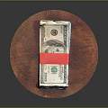 Stack of US Dollar Bills Secured with Red Tape on Round Wooden Board 3d model