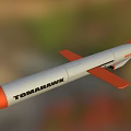 Tomahawk Missile With Orange Nose White Body And Orange Tail Fins Flying Over Natural Landscape