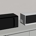 Modern Two Black And White Microwave Ovens On White Countertop With Light Gray Wall
