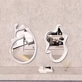 Two Irregular Shaped White Mirrors On Beige Textured Wall With Books And Decor
