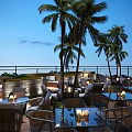 Chic Rooftop Bar With Outdoor Seating Palm Trees Candlelit Tables And Ocean Night View