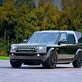 Stylish Black Land Rover SUV Parked on Stone Pavement with Autumn Forest Background
