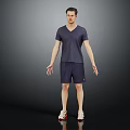 Man in V neck T shirt and shorts standing with sneakers on dark background