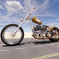 Custom Gold and Black Motorcycle on Road with Blue Sky White Clouds